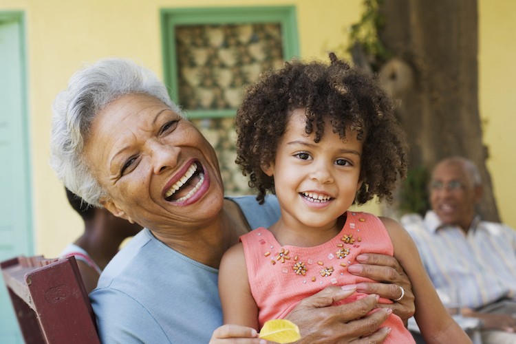 smiling older woman holding happy preschooler