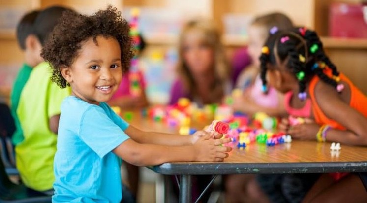 child at classroom table with classmates